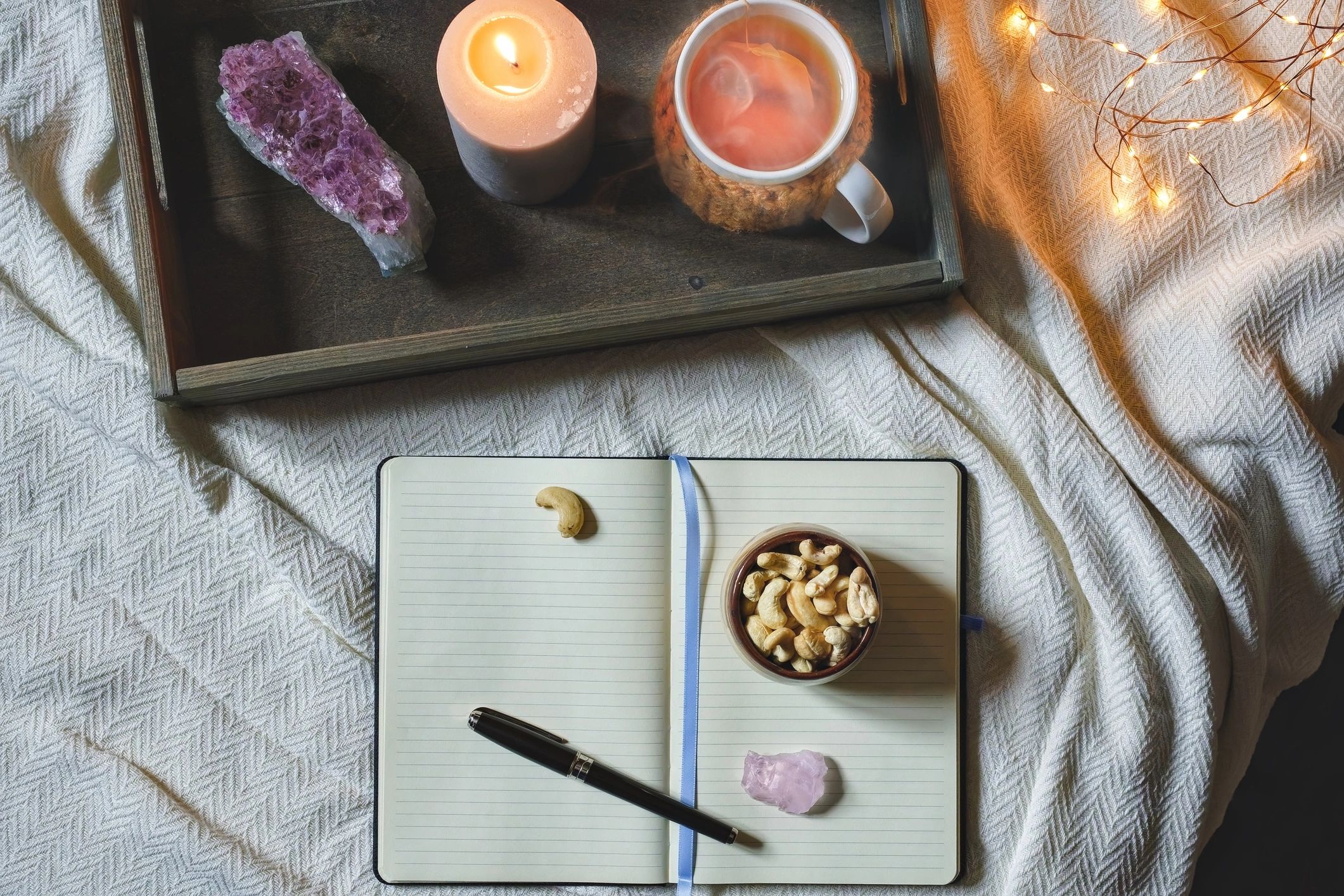 Cozy evening journal scene with tea and candle