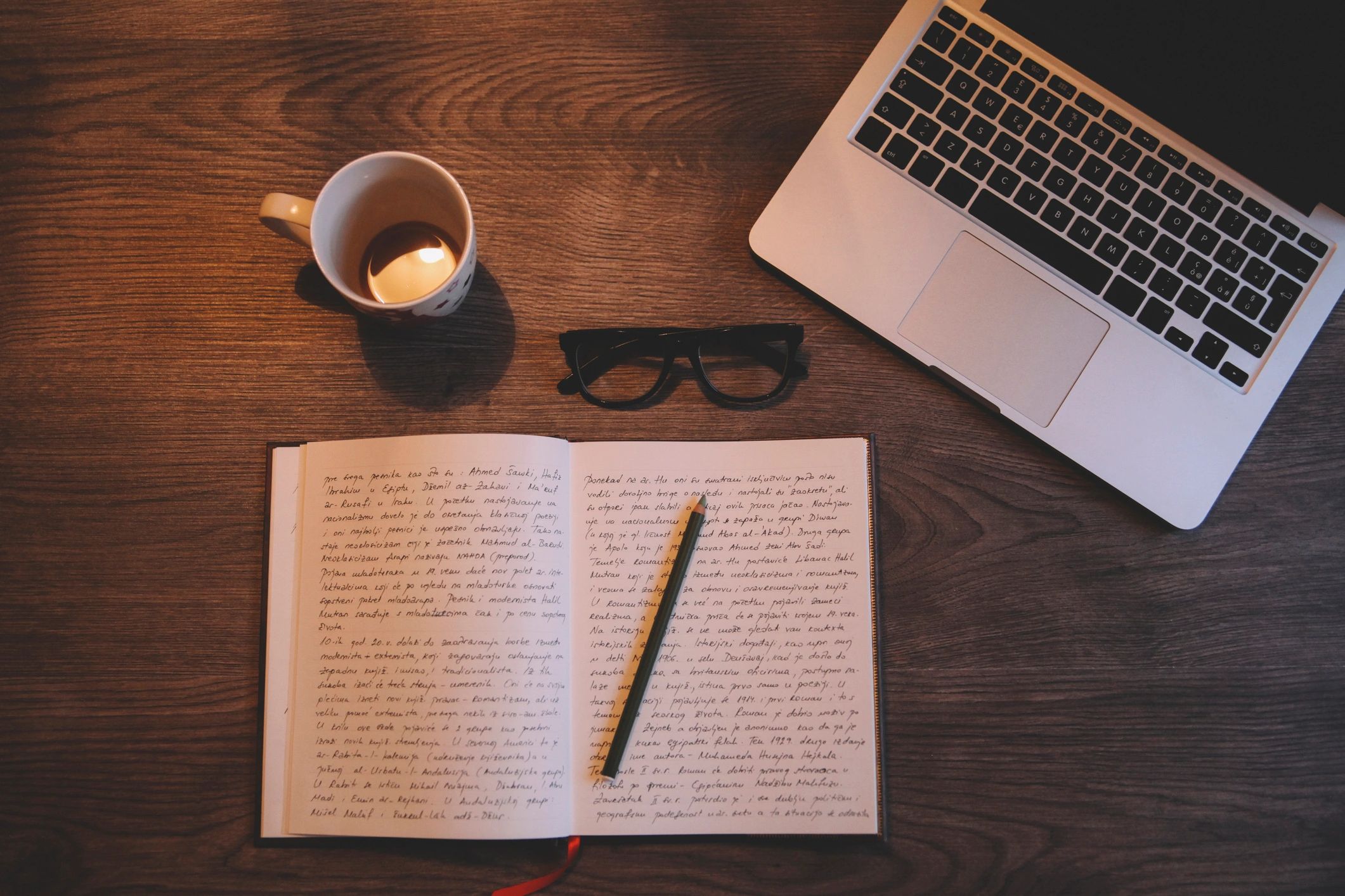 Open journal beside a laptop and coffee